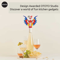 OTOTO Pinot Parrot Opener on a wine bottle with party setup. A design-awarded kitchen gadget that adds fun to any gathering.