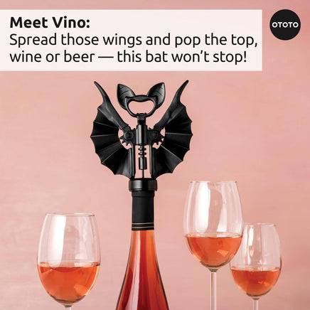 OTOTO Vino bat-shaped corkscrew on wine bottle with wings spread, surrounded by wine glasses. Fun Halloween wine opener for kitchen or bar use.