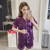 Women's silk satin pajamas in a rich purple color with short sleeves and shorts, offering luxurious comfort and elegance for sleepwear.