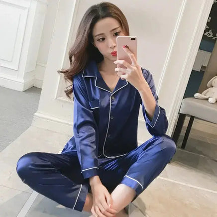 Women Silk Satin Pajamas in navy blue with white piping, featuring a button-up top and matching pants. Perfect for luxurious comfort and relaxation.