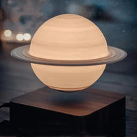 Levitating Saturn lamp with glowing rings on a wooden base, creating a celestial ambiance for home decor.