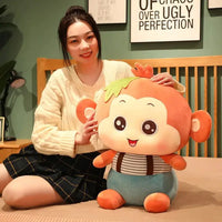 Large orange Sitting Monkey Plush Toy held by a smiling woman, showcasing its soft texture and playful design.