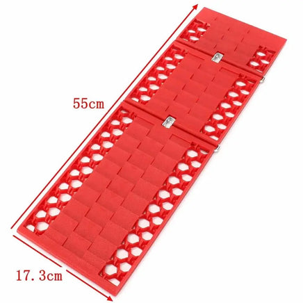 Red car tire traction grip tracks measuring 55cm by 17.3cm, designed for compact storage and emergency vehicle recovery.