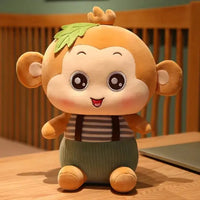 Adorable sitting monkey plush toy with big eyes, striped shirt, green overalls, and a leaf detail on its head, perfect for all ages.