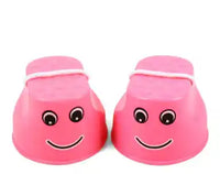 Pink children's outdoor stilts with smiley face design and rope handles for fun balance training and motor skill development.