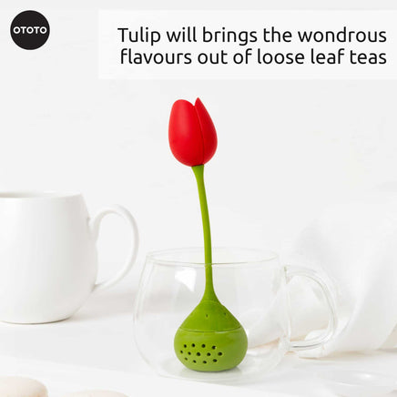 Cute Tea Infuser by OTOTO shaped like a red tulip with green stem, placed in a clear glass cup, ideal for steeping loose leaf tea.