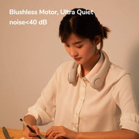Mini Bladeless Neck Fan Outdoor worn by woman at desk, showcasing lightweight, quiet design with noise under 40 dB for hands-free cooling comfort.