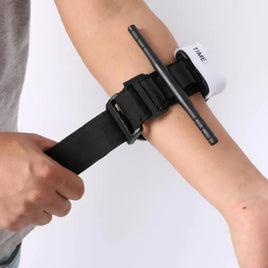 Emergency tourniquet being applied to an arm, showcasing its adjustable strap and portable design for first aid use.