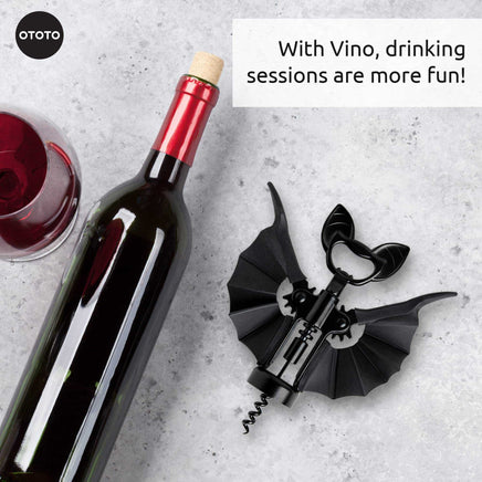 OTOTO Vino Spooky Bat Opener lying next to a wine bottle. A fun and functional corkscrew and bottle opener for festive drinking sessions.