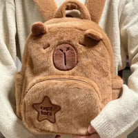 Capybara Plush Little Backpack with a cute capybara face design, soft plush material, and front pocket featuring a star patch.