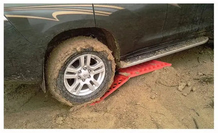 Car tire traction emergency grip tracks assisting a vehicle stuck in mud, showcasing their effectiveness in tough conditions.