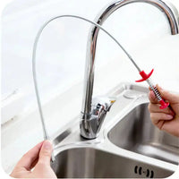 Flexible spring pipe dredging tool with a red handle, shown in use for cleaning a kitchen sink drain.