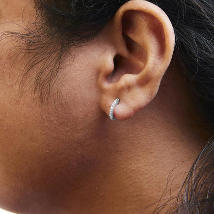 .925 sterling silver diamond petite hoop earrings worn on an ear, showcasing their elegant and minimalistic design.