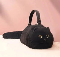 Black handmade plush cat bag with golden eyes and a black strap, featuring a soft tail and plush texture for a unique handbag design.