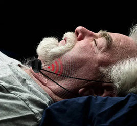 Elderly man sleeping with an intelligent anti-snoring device on his throat, emitting signals to reduce snoring for better sleep quality.