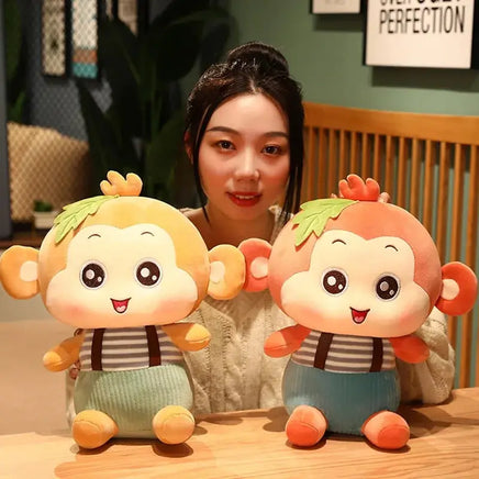 Two Sitting Monkey Plush Toys in orange and yellow displayed on a table, highlighting their charming details.