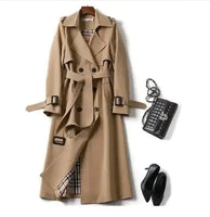 Classic beige trench coat with a belted waist, double-breasted design, and plaid lining, styled with a black handbag and heels.