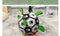 Black and white dog football toy with paw print design and green straps, placed on a gray carpet.