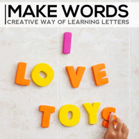 Foam letters spelling 'LOVE TOYS' on a bathroom wall, showcasing creative and interactive learning for children during bath time.