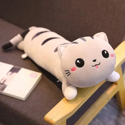 Cute Cat Pillow Plush Toy featuring a gray and white cat design with pink cheeks, lying on a chair. Perfect for cuddling and play.