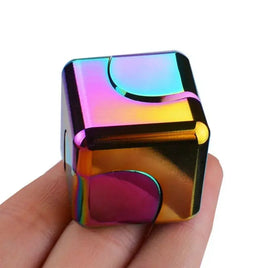 Rainbow-colored fidget spinner stress relief cube held in hand, featuring a smooth metallic finish and curved design for anxiety relief.