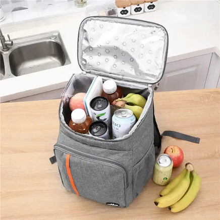 Open portable thermal lunch bag filled with fruits, drinks, and snacks, displayed on a kitchen counter for meal storage convenience.