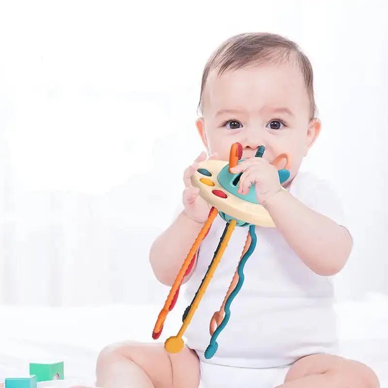 Baby exploring a sensory toy with pull strings, fostering tactile stimulation and early developmental skills.
