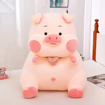 Adorable soft pig toy with pink cheeks, a heart-shaped 'Love' pendant, and a plush design, perfect for cuddling and gifting.