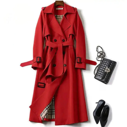 Classic red trench coat with a belted waist, plaid inner lining, and button details, styled with black heels and a quilted handbag.