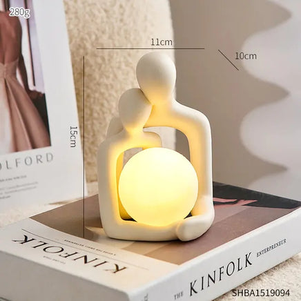 Nordic couple statue with glowing orb, featuring a minimalist design and compact dimensions for modern decor.