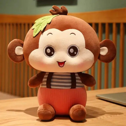 Adorable sitting monkey plush toy with a striped shirt and leaf detail, perfect for cuddling and gifting for all ages.