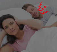 Frustrated woman covering her ears while her partner snores loudly, emphasizing the need for an intelligent anti-snoring device for peaceful sleep.