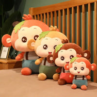 Set of Sitting Monkey Plush Toys in different sizes and colors arranged on a bed, ideal for all ages.