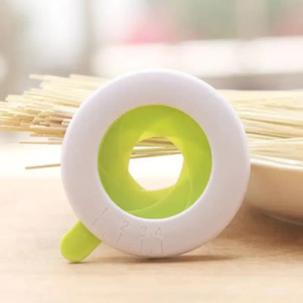 Pasta measurer tool placed near uncooked spaghetti, showcasing its adjustable portion settings. A useful kitchen gadget for perfect pasta servings.