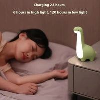 Green dinosaur night light on a bedside table, showcasing its long battery life and soft glow, ideal for nighttime use.