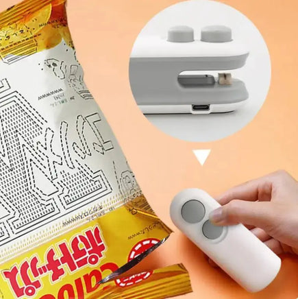 White handheld vacuum sealing machine sealing a chip bag, showcasing its USB rechargeable feature for food preservation.