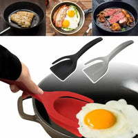 2-in-1 kitchen gadget set in red and black, shown flipping eggs, steak, and bacon in a frying pan for versatile cooking.