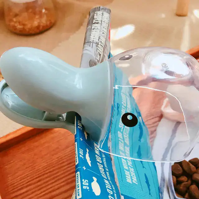 Pet Food Spoon with a cute animal-shaped design, featuring a clip for sealing pet food bags. Made of durable plastic for easy mealtime use.