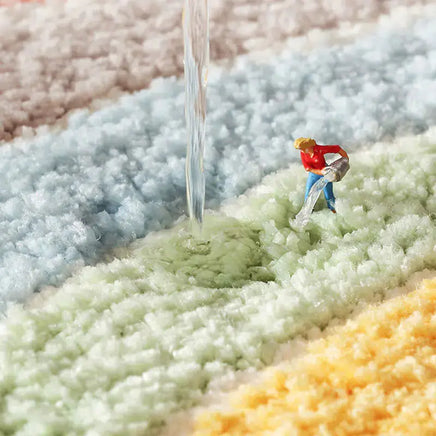 Water-resistant feature of the 60cm Rainbow Art Cartoon Carpet demonstrated with water pouring onto its colorful, soft surface.