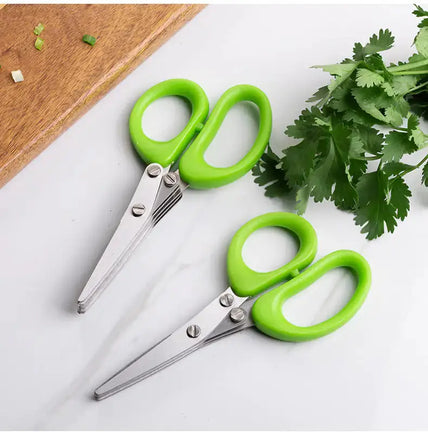 Pair of multifunctional green onion scissors with green handles placed on a countertop next to fresh cilantro, perfect for kitchen tasks.