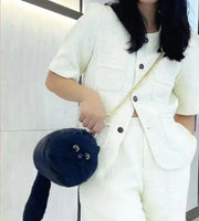 Woman carrying a black handmade plush cat messenger bag with a gold chain strap, showcasing a fun and unique accessory for casual outfits.