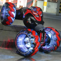 Red RC stunt car with LED wheels performing a stunt on a concrete surface, showcasing its off-road capabilities.