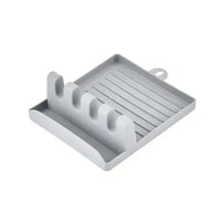 Gray spatula drain rack gadget with four slots and a drip tray, perfect for holding kitchen utensils.