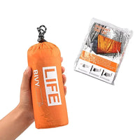 Hand holding an orange survival tube emergency tent in a compact bag with whistle. Includes packaging for easy storage and portability.