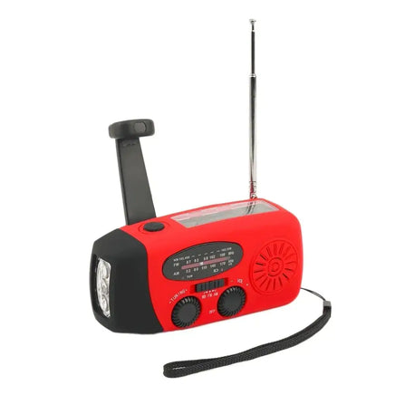 Red portable emergency radio with LED flashlight, AM/FM/WB tuning dials, solar panel, and hand crank for power.