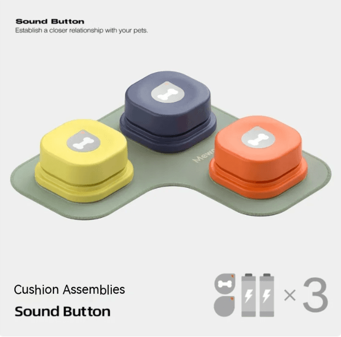Set of three colorful cushion sound buttons in yellow, navy, and orange with dog bone icons, on a soft green base for pet interaction.