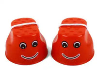 Red children's outdoor stilts with fun smiley faces and rope handles, perfect for safe and interactive balance training activities.