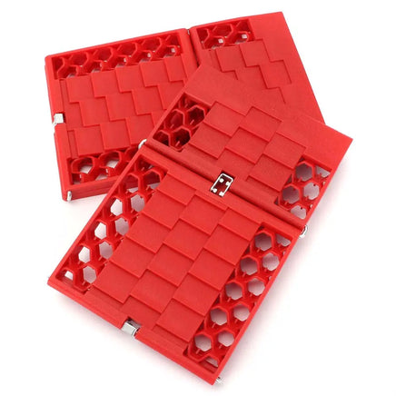 Red car tire traction emergency grip tracks with interlocking design for enhanced vehicle stability in slippery conditions.