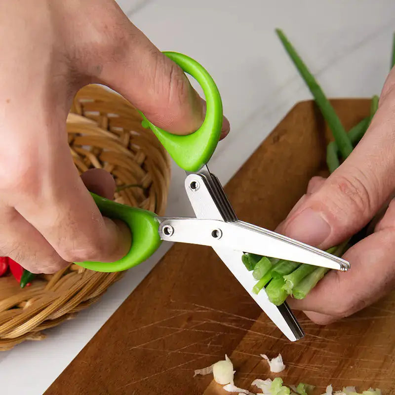 Person using multifunctional green onion scissors to cut fresh green onions on a wooden cutting board, showcasing its efficiency.