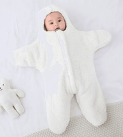 Baby in white plush bear costume on white background